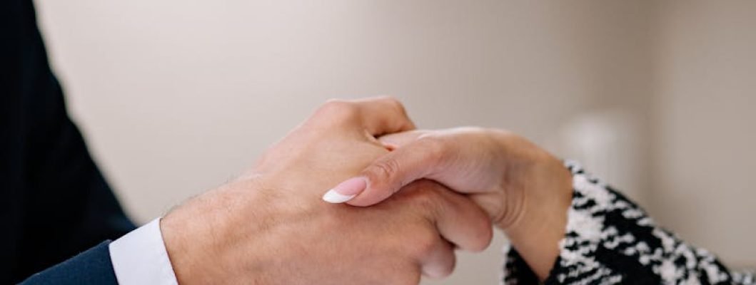 Close-up of a professional handshake between colleagues in a modern office setting, symbolizing agreement.